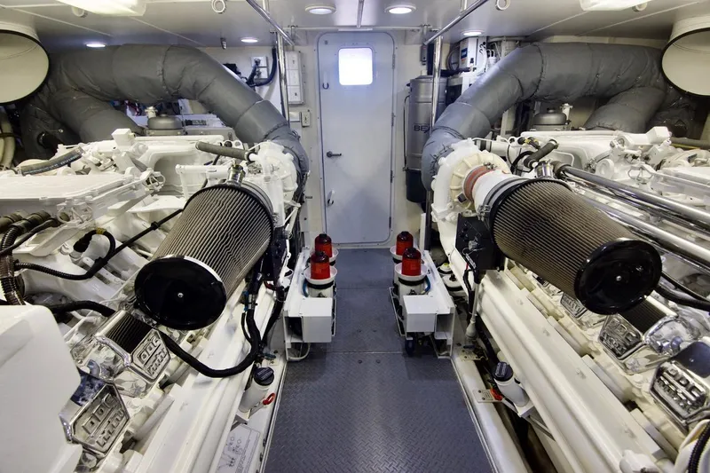 T.t. Amore Yacht Photos Pics Engine room of 2004 West Bay Cockpit Pilot House Motoryacht, showcasing dual engines and mechanical systems.