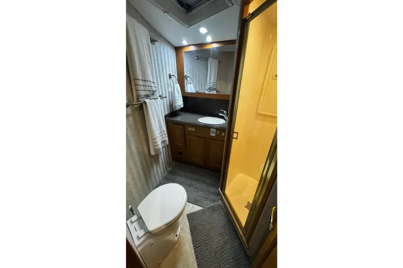 Hammertime Yacht Photos Pics Bathroom interior of 2002 Cavileer 48 Flybridge Sportfish with shower, sink, and toilet.