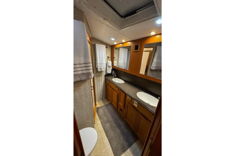 Hammertime Yacht Photos Pics Luxurious bathroom in 2002 Cavileer 48 Flybridge Sportfish yacht with dual sinks and wooden cabinetry.