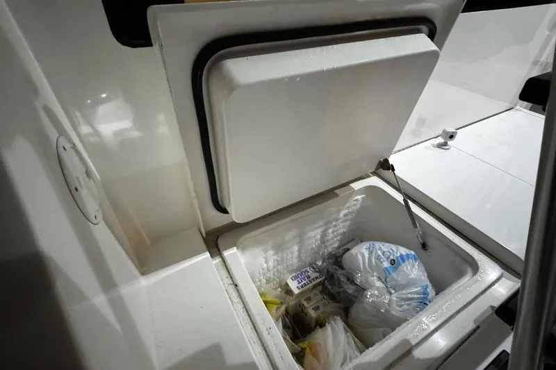 Hammertime Yacht Photos Pics Open storage compartment on 2002 Cavileer 48 Flybridge Sportfish boat, containing various items.