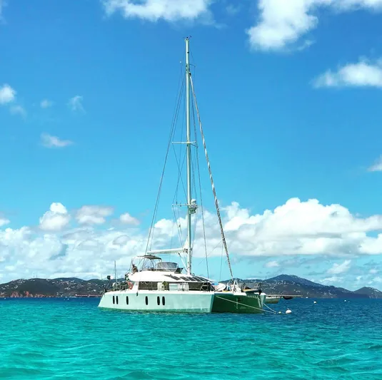 Chasing Waterfalls Yacht Photos Pics Sailing yacht Tayana Isara 50, 2014 model, anchored in turquoise waters under a clear blue sky.