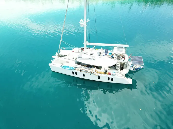 Chasing Waterfalls Yacht Photos Pics Aerial view of 2014 Tayana Isara 50 catamaran on calm blue water.