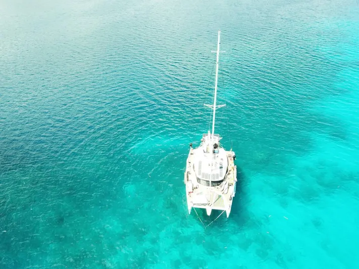 Chasing Waterfalls Yacht Photos Pics Aerial view of 2014 Tayana Isara 50 catamaran on clear turquoise water.