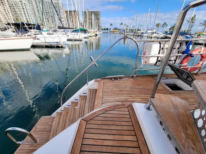 Chasing Waterfalls Yacht Photos Pics Tayana Isara 50 yacht docked in a marina, showcasing elegant wooden deck and serene waters.