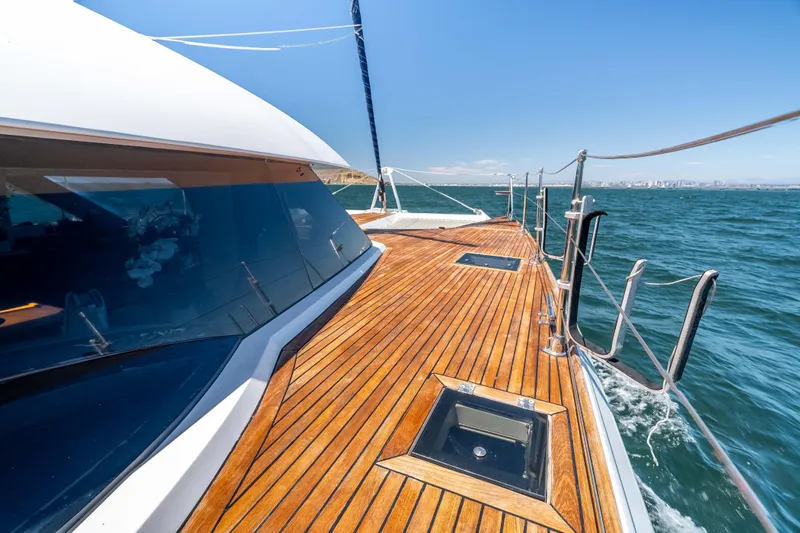 Chasing Waterfalls Yacht Photos Pics 2014 Tayana Isara 50 yacht with sleek wooden deck sailing on open water.