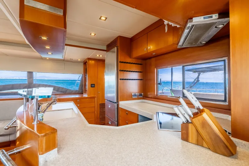 Chasing Waterfalls Yacht Photos Pics Luxurious 2014 Tayana Isara 50 yacht kitchen with ocean view, modern appliances, and wooden cabinetry.