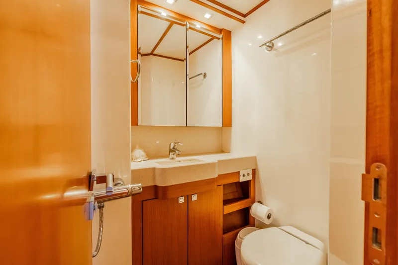 Chasing Waterfalls Yacht Photos Pics Luxurious bathroom in 2014 Tayana Isara 50 yacht, featuring wooden cabinetry and modern fixtures.