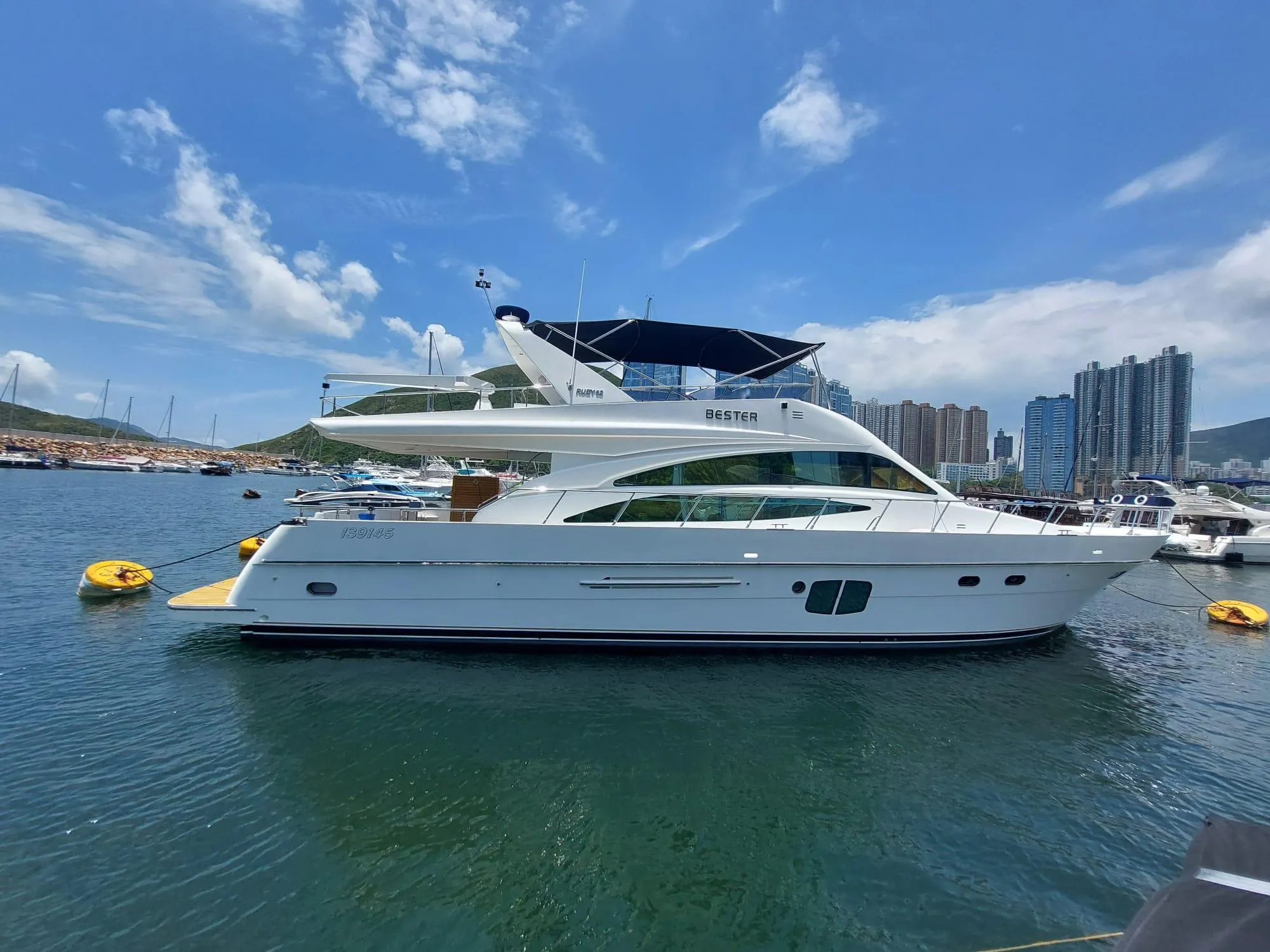 Luxurious 2009 Ruby 62 yacht docked in a marina under a clear blue sky.