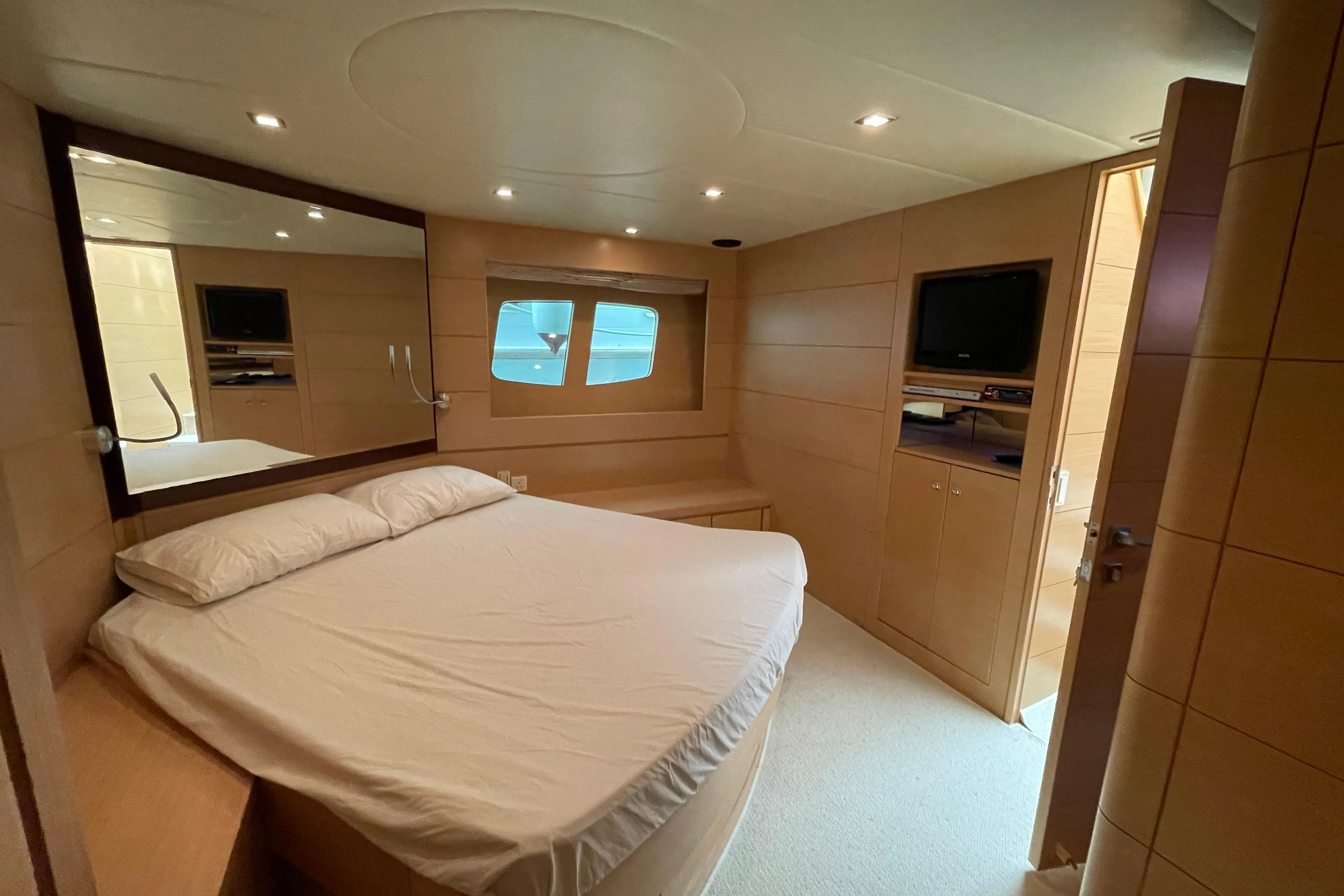 Luxurious bedroom interior of 2009 Ruby 62 yacht with modern furnishings and ocean view.
