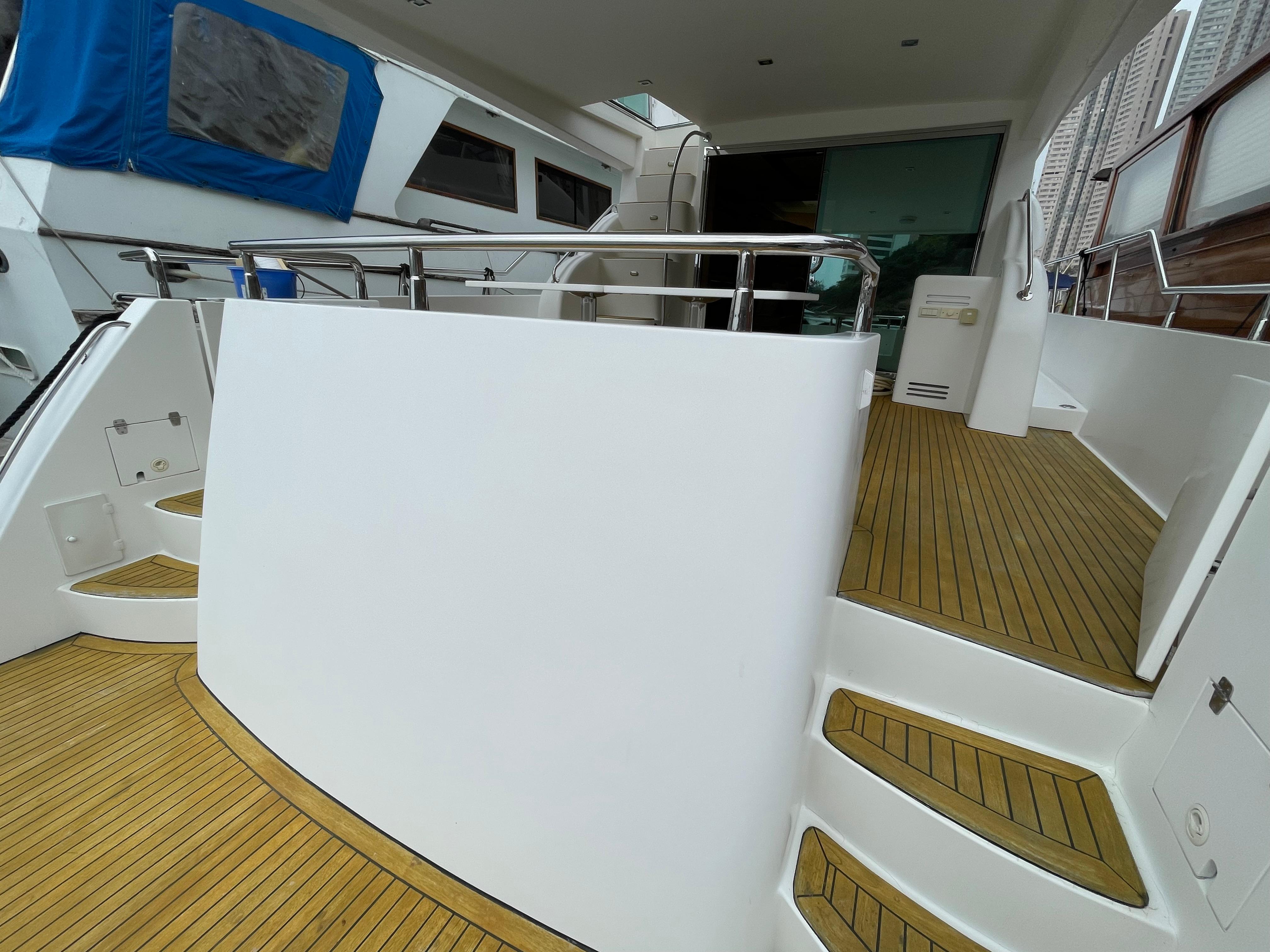 Luxury yacht deck with wooden flooring, featuring sleek design and modern amenities, Ruby 62 model.