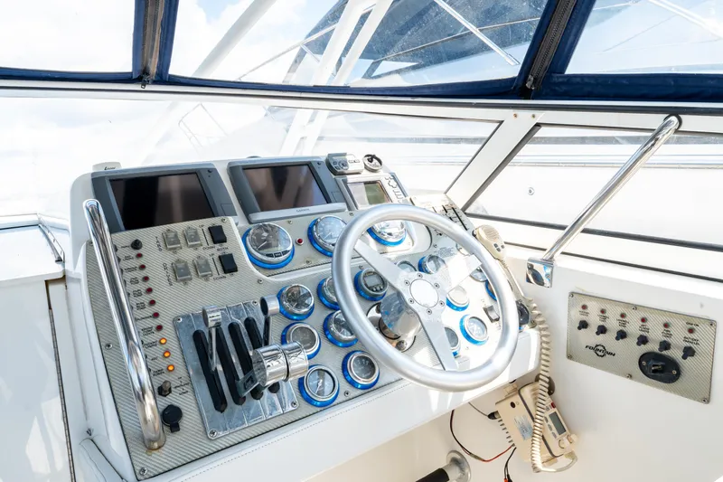  Yacht Photos Pics Control panel of a 2008 Fountain 38 Sportfish Cruiser with steering wheel and navigation instruments.