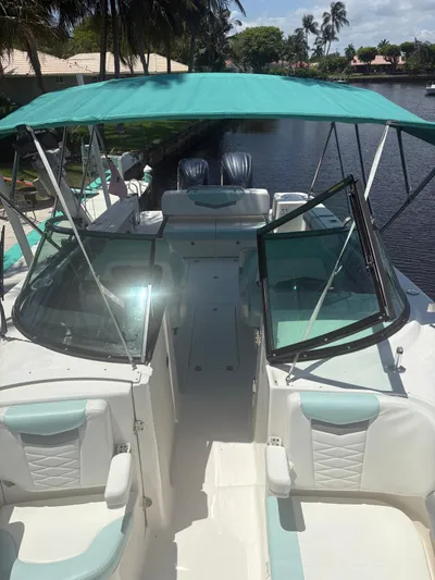  Yacht Photos Pics 2022 Robalo R317 Dual Console boat with teal canopy on a sunny day.