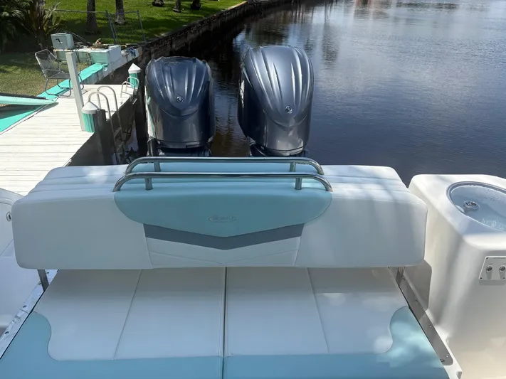  Yacht Photos Pics 2022 Robalo R317 Dual Console boat with twin engines docked by a serene waterfront.