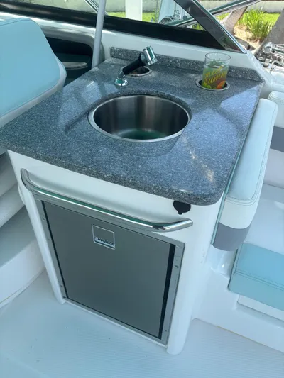  Yacht Photos Pics 2022 Robalo R317 Dual Console boat kitchenette with sink and drink on counter.