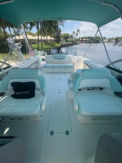  Yacht Photos Pics 2022 Robalo R317 Dual Console boat with spacious seating, docked by a scenic waterfront.