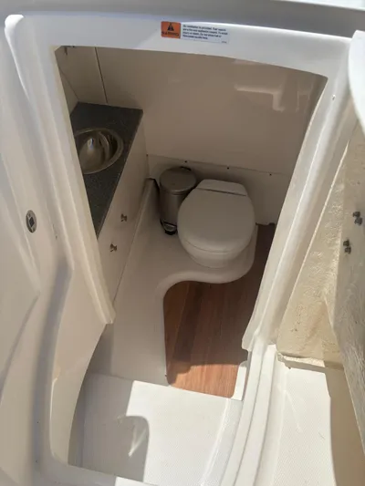  Yacht Photos Pics 2022 Robalo R317 Dual Console boat bathroom with toilet and sink.