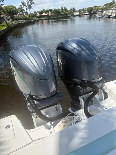  Yacht Photos Pics 2022 Robalo R317 Dual Console with twin outboard engines on a calm waterway.