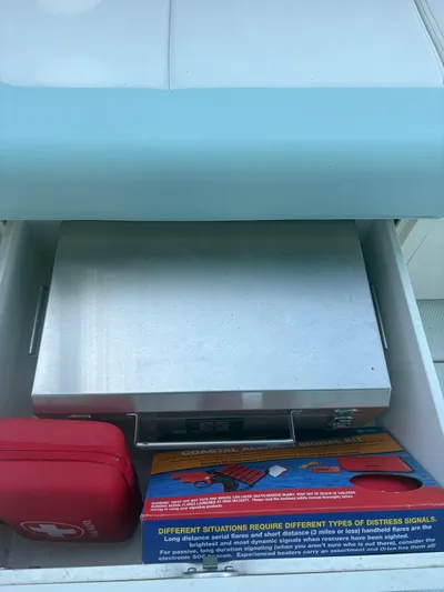  Yacht Photos Pics Storage compartment in a 2022 Robalo R317 Dual Console boat with safety equipment.