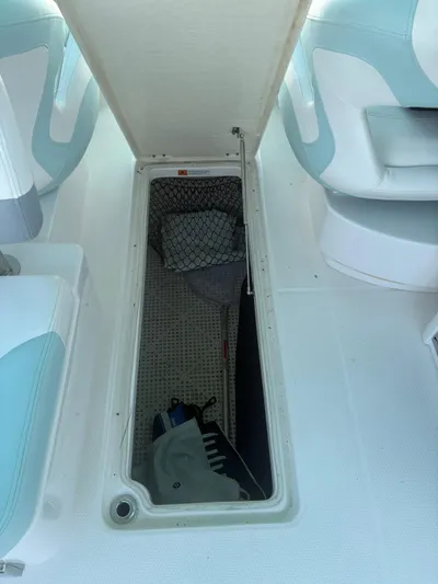  Yacht Photos Pics 2022 Robalo R317 Dual Console storage compartment with open hatch, showcasing interior space.