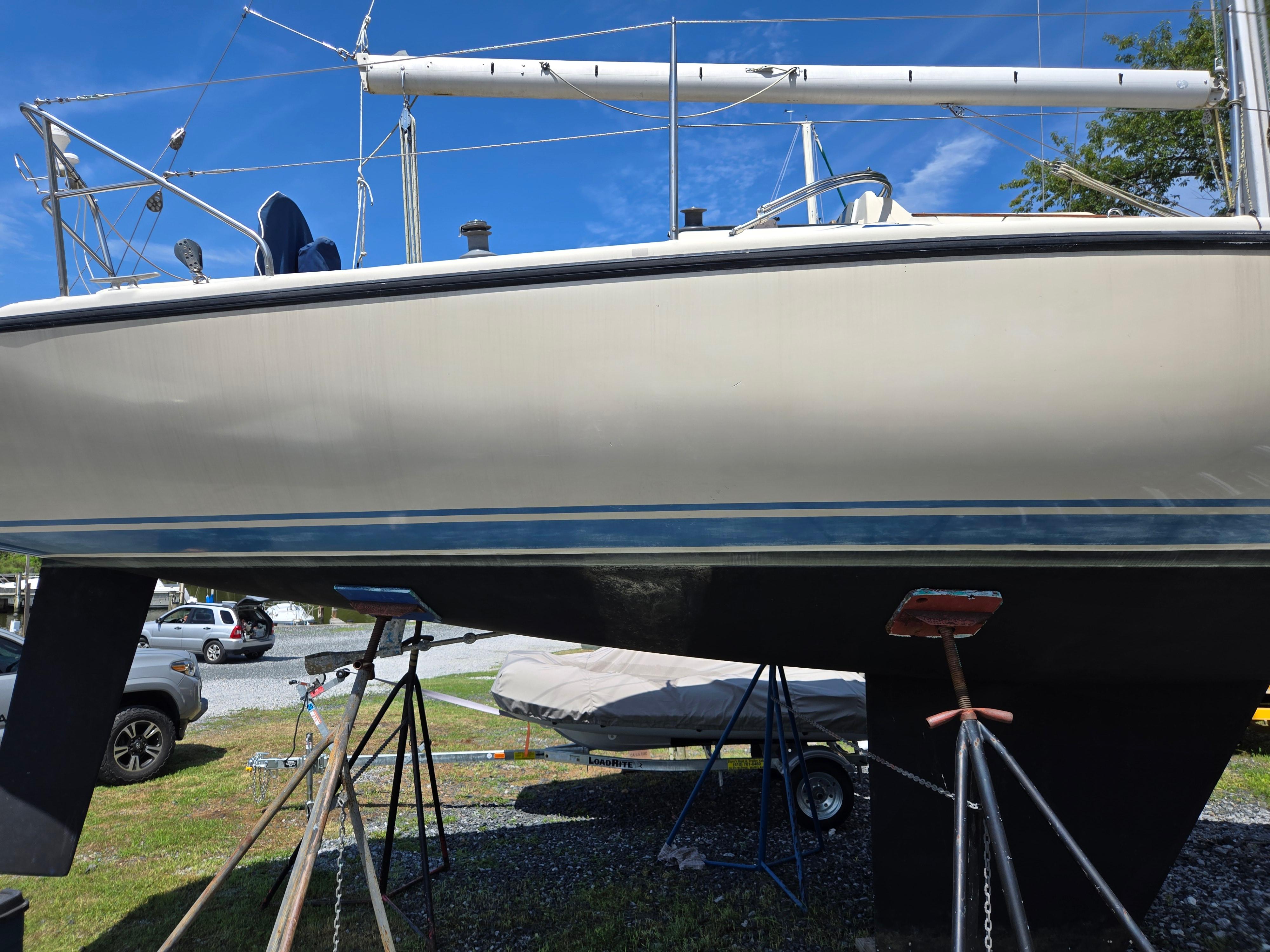 1987 Dehler Optima 34 sailboat on stands, with visible hull and mast.