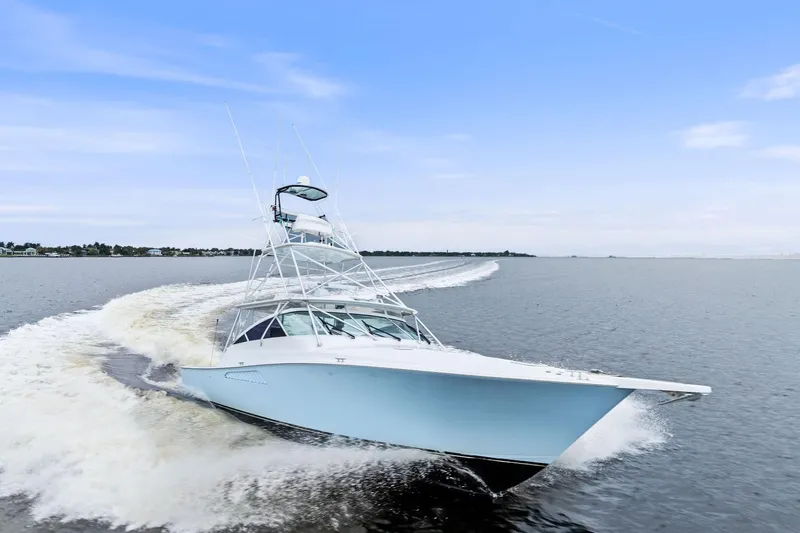 Urgent Sea Yacht Photos Pics 2003 Viking 45 Open yacht cruising on open water, creating a dynamic wake.