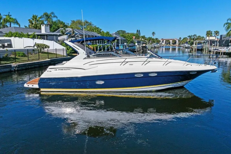 Yaeli Yacht Photos Pics 2005 Regal Commodore 3560 yacht on a sunny canal, surrounded by waterfront homes.