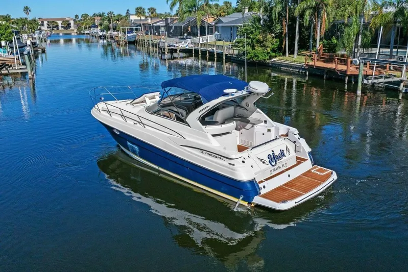 Yaeli Yacht Photos Pics 2005 Regal Commodore 3560 yacht cruising in a scenic canal with palm trees.