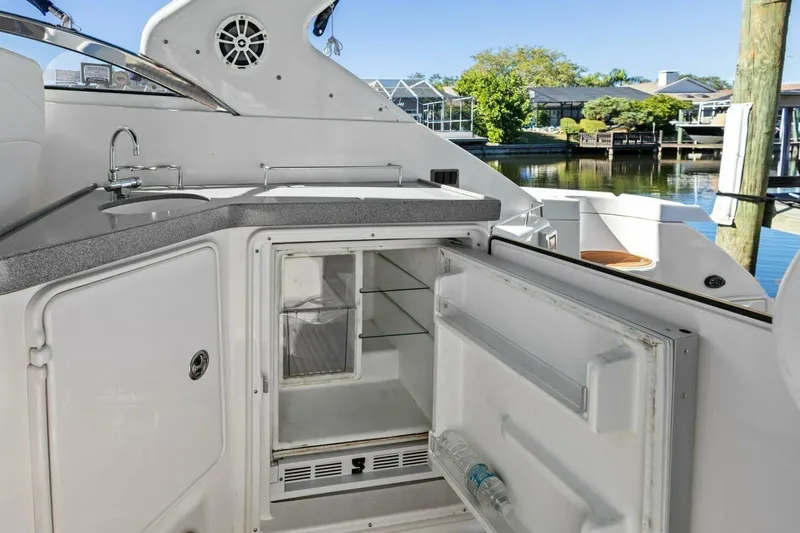 Yaeli Yacht Photos Pics 2005 Regal Commodore 3560 yacht kitchenette with open fridge and sink, dockside view.