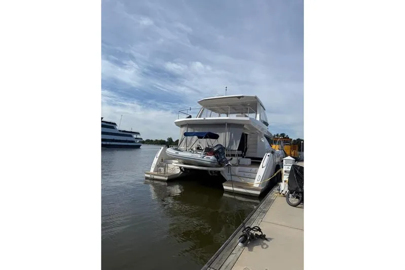 Wander Twins Yacht Photos Pics 2023 Leopard 46 PC yacht docked at marina under cloudy sky.