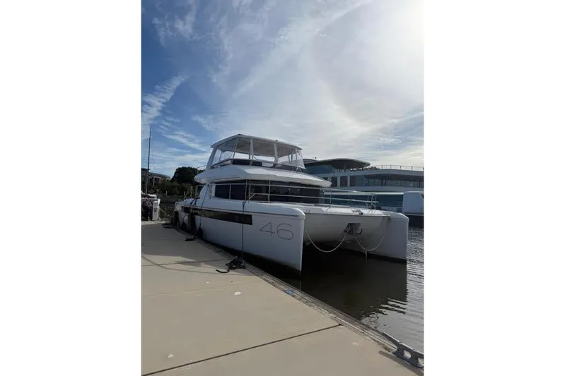 Wander Twins Yacht Photos Pics 2023 Leopard 46 PC catamaran docked at marina under clear sky.