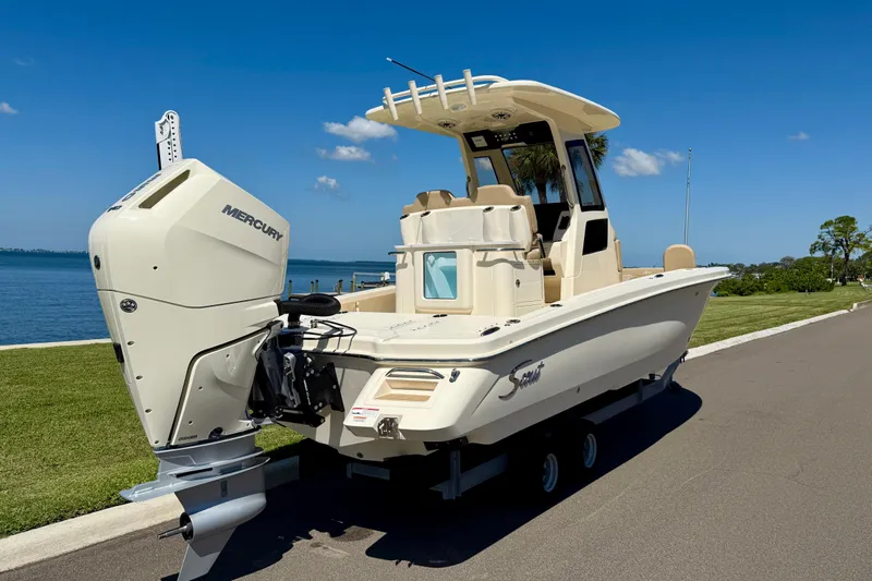 Yacht Photos Pics 2025 Scout 261 XSS boat with Mercury engine, parked by a scenic waterfront.