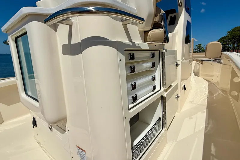  Yacht Photos Pics 2025 Scout 261 XSS boat interior with storage compartments and seating under clear blue sky.