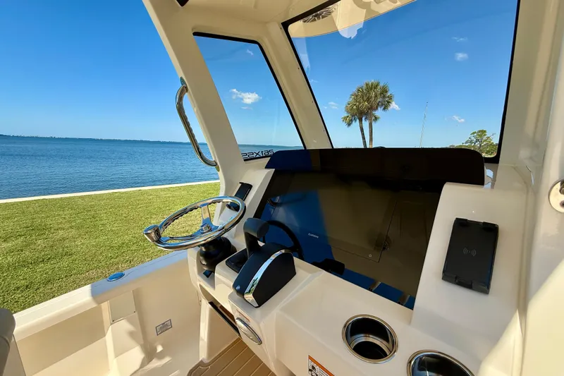  Yacht Photos Pics 2025 Scout 261 XSS boat helm with steering wheel, controls, and scenic water view.