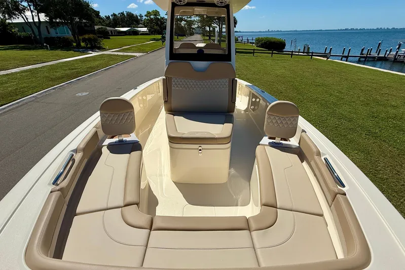  Yacht Photos Pics 2025 Scout 261 XSS boat interior with beige seating, docked near a scenic waterfront.