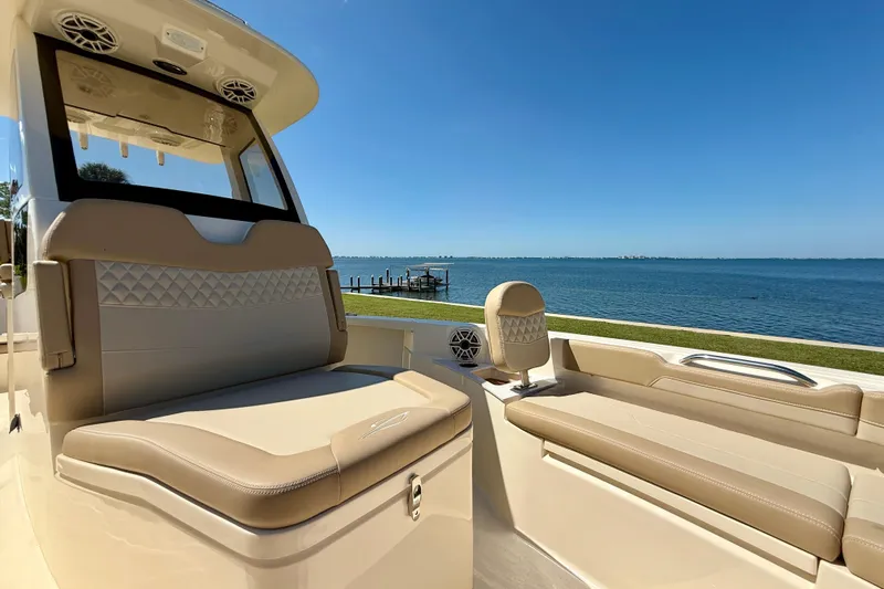  Yacht Photos Pics 2025 Scout 261 XSS boat interior with beige seating, overlooking a serene waterfront.