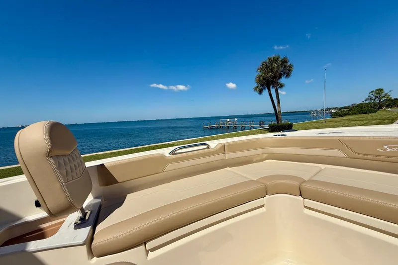  Yacht Photos Pics 2025 Scout 261 XSS boat interior with beige seating, overlooking a serene waterfront view.