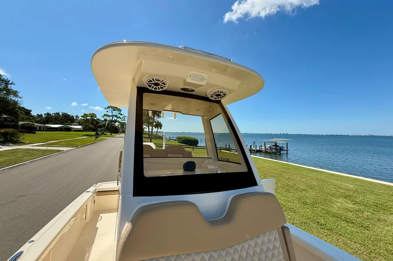  Yacht Photos Pics 2025 Scout 261 XSS boat on a scenic waterfront road under a clear blue sky.