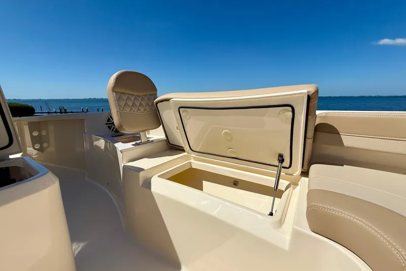  Yacht Photos Pics 2025 Scout 261 XSS boat interior with open storage compartment, beige seating, and ocean view.