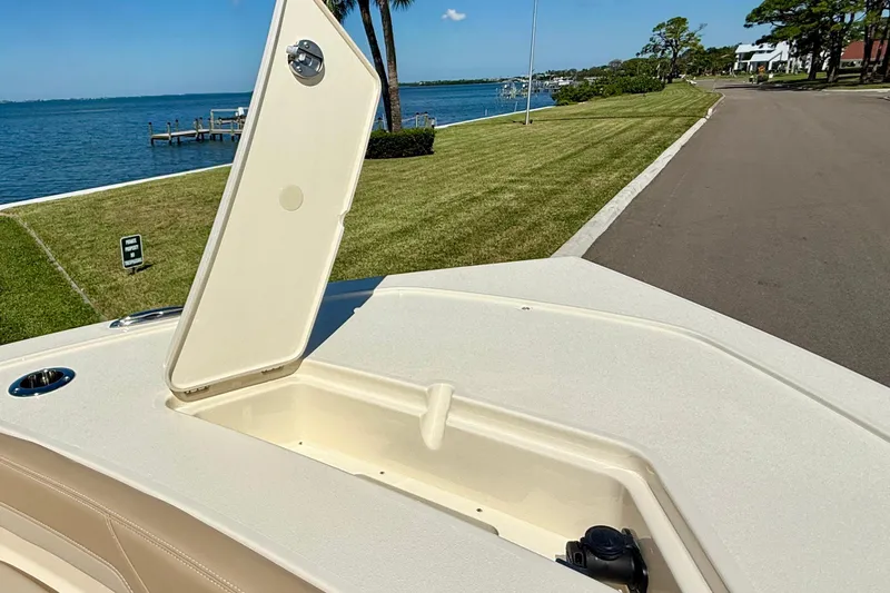  Yacht Photos Pics 2025 Scout 261 XSS boat with open storage compartment, near waterfront and road.