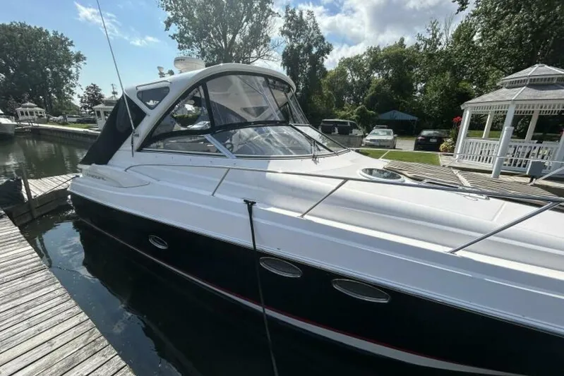  Yacht Photos Pics 2007 Regal 3760 Commodore yacht docked by a wooden pier, surrounded by trees.