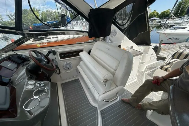  Yacht Photos Pics 2007 Regal 3760 Commodore cockpit with steering wheel, seating, and docked boats in background.