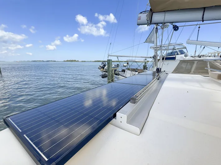 Alisei Yacht Photos Pics Fountaine Pajot Helia 44 Evolution 2017 catamaran with solar panels on deck, docked by the sea.