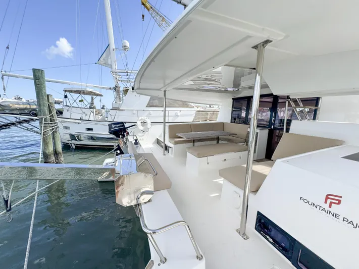 Alisei Yacht Photos Pics 2017 Fountaine Pajot Helia 44 Evolution catamaran docked, featuring spacious outdoor seating area.