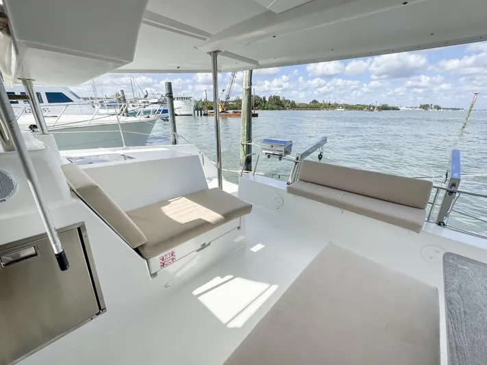 Alisei Yacht Photos Pics 2017 Fountaine Pajot Helia 44 Evolution catamaran interior with seating, docked by the water.