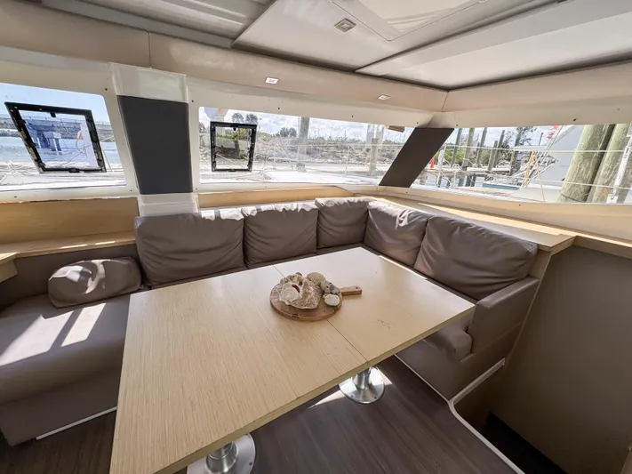 Alisei Yacht Photos Pics Interior of 2017 Fountaine Pajot Helia 44 Evolution catamaran with cozy seating and table.