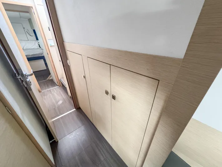 Alisei Yacht Photos Pics Interior hallway of 2017 Fountaine Pajot Helia 44 Evolution catamaran, featuring wooden cabinetry.