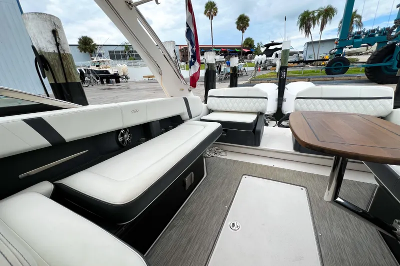  Yacht Photos Pics 2019 Regal 29 OBX boat interior with white seating and wooden table, dockside view.