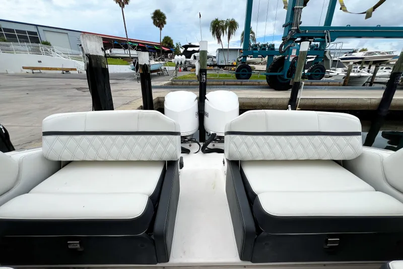  Yacht Photos Pics 2019 Regal 29 OBX boat interior with white cushioned seating at a marina.