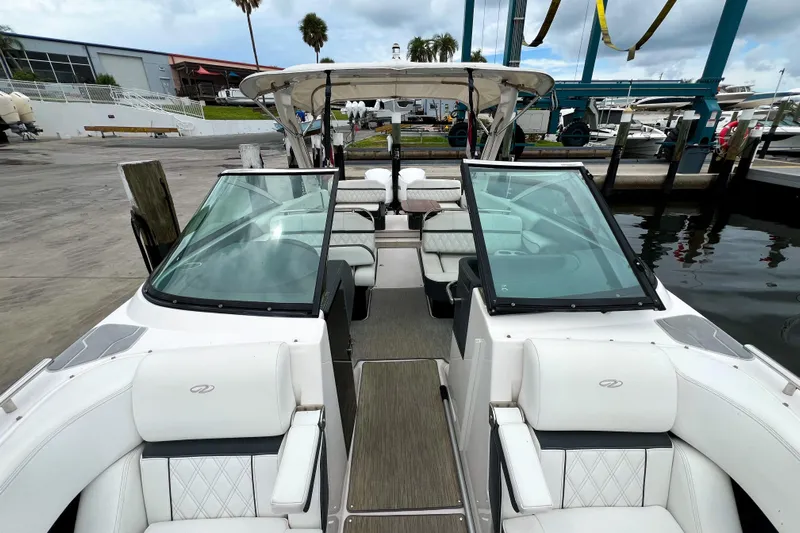  Yacht Photos Pics 2019 Regal 29 OBX boat with white seating, docked at a marina.