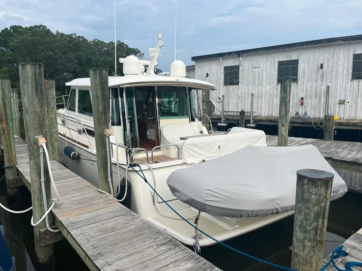 Freedom Yacht Photos Pics 2021 Sabre 48 Salon Express yacht docked at marina with covered dinghy.